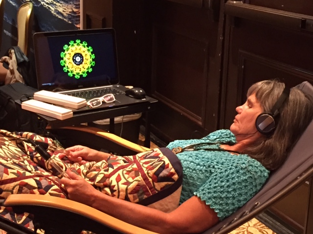 A person in an Ascension11 session, holding crystal rods